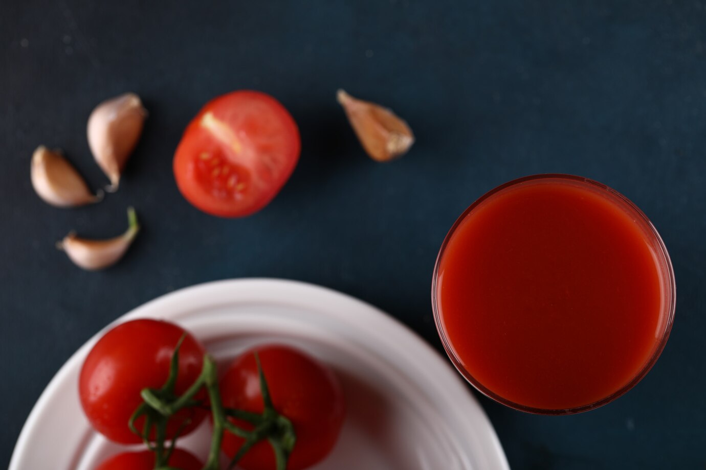 red tomatoes with water sprinkles them white plate with glass juice top view 114579 5134
